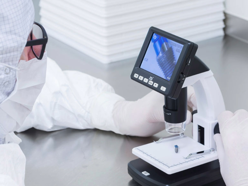 Lab technician performing a validation test on a medical device using specialized equipment.