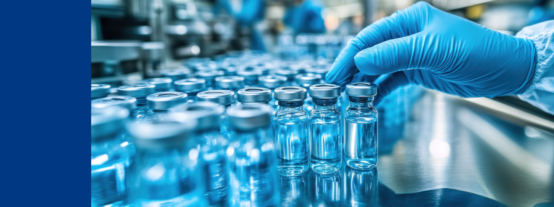 A gloved hand handling small glass vials filled with a clear liquid in Eurofins BioPharma Product Testing laboratory. The vials are arranged in rows and there are more vials and blurred figures in the background, indicating an industrial environment focused on packaging or drug delivery systems validation. This process involves ensuring that packaging and drug delivery systems are properly validated to maintain the integrity, safety, and efficacy of pharmaceutical products during storage and administration.