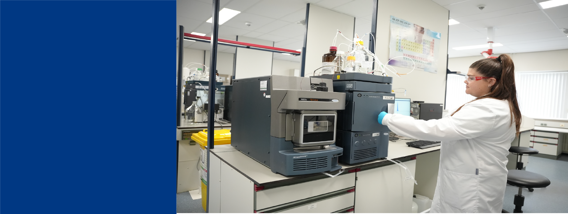 Scientist in a white lab coat measuring Spedia samples on a UPLC-MS machine, performing Culture Media Analysis.