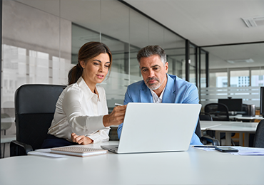 Two professionals collaborating at a desk with a laptop in a modern office, representing MDS Consulting’s smart and secure validation processes for regulated medical devices.